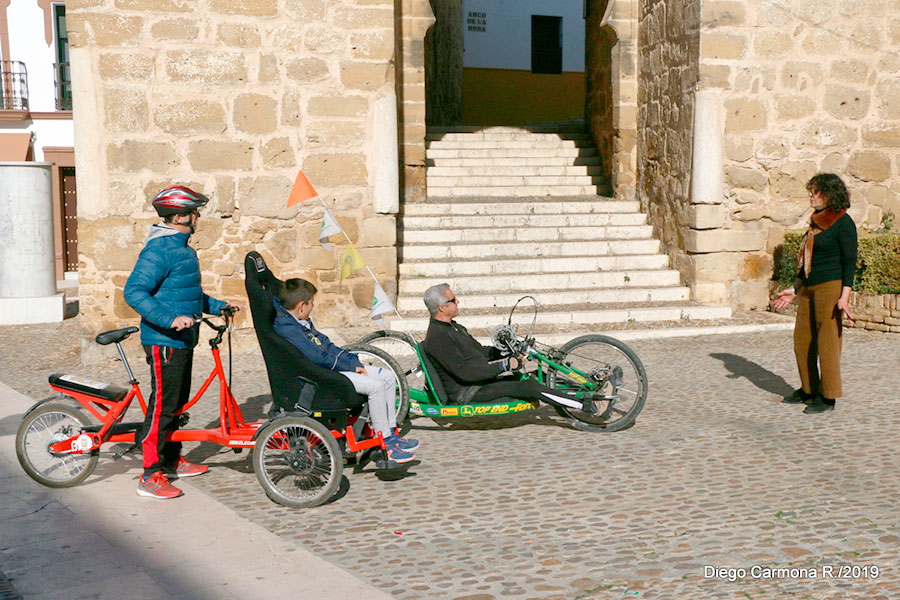Guía turística acompañanado a visitantes que usan bicicletas adaptadas para poder moverse libremente por Marchena.